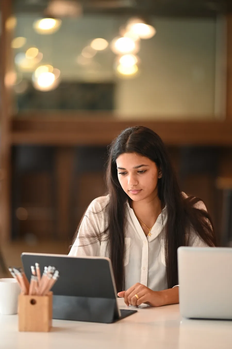 A learner working on her tablet and laptop