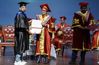 A graduate receiving their certificate on stage