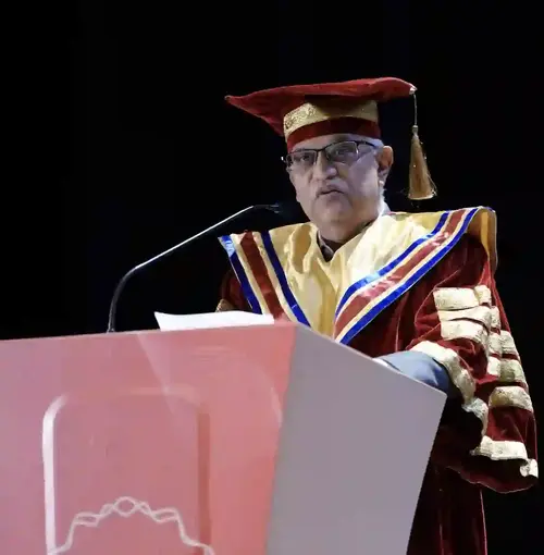 A dignitary addressing graduates at the graduation ceremony
