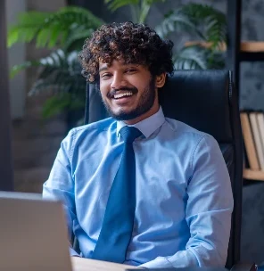 A young professional smiling at his laptop